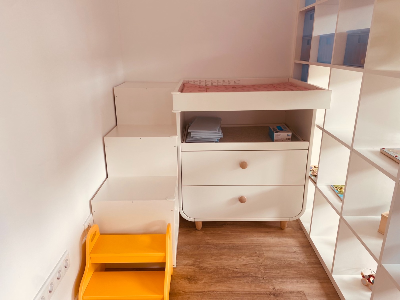 Wickelbereich mit Wickelkommode, Kindertreppe und Regalen